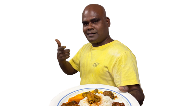 料理のお皿を差し出す、黄色いTシャツのテーヴァン・マハリンガム